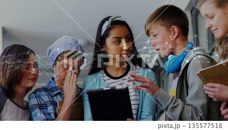 Collaborating five students gathering around tablet in school corridor, with face recognition 135577518