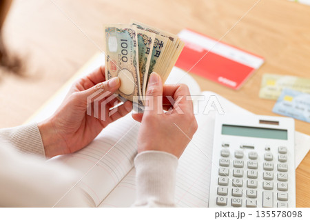 家計簿をつけるミドル女性の手元 135578098