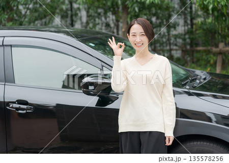 車の前に立つ30代女性 135578256