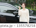 車の前に立つ30代女性 135578258