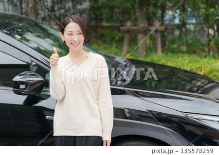 車の前に立つ30代女性 135578259