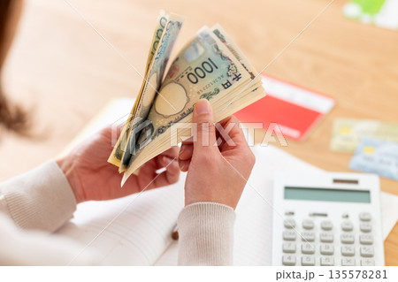 家計簿をつけるミドル女性の手元 家計簿をつけるミドル女性の手元 135578281
