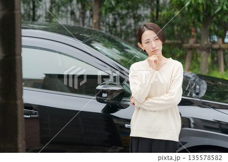 車の前で考える女性 車の前で考える女性 135578582