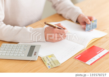 家計簿をつけるミドル女性の手元 135578727