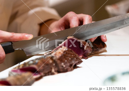 鰹のタタキの刺身を切る 鰹のタタキの刺身を切る 135578836