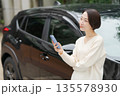 車の前でスマホを操作する女性 135578930