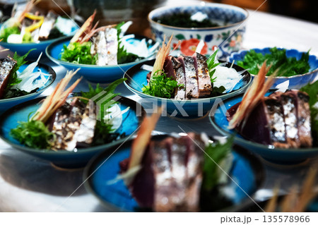 藁焼き鰹のタタキを盛り付ける 135578966