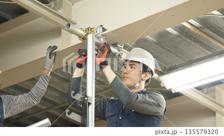 単管パイプを取り付ける職人 単管パイプを取り付ける職人 135579320