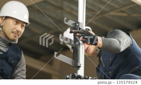 単管パイプを取り付ける職人 135579324