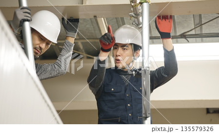 単管パイプを取り付ける職人 135579326