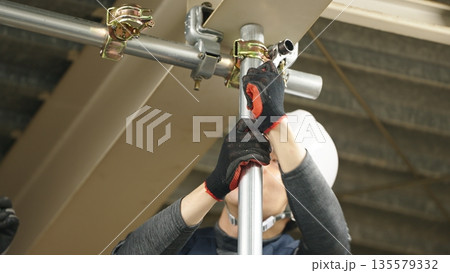 単管パイプを取り付ける職人 135579332