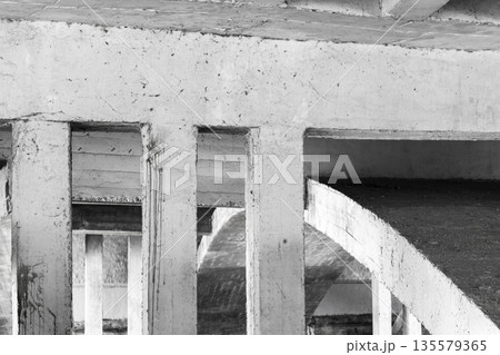 Monochrome scene showing rugged concrete pillars and curved ramp 135579365