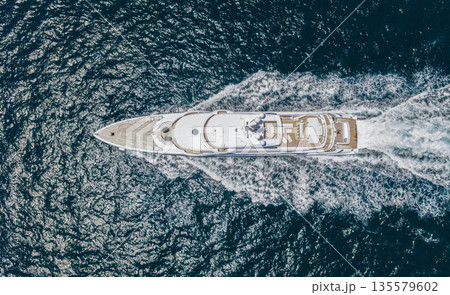 Summer sea vacation. Boat trip. Luxury lifestyle and traveling. Sea boat go to yacht marina. Yachting and boating marina. Yacht boat sailing. Top view. Aerial view luxury motorboat in sea 135579602