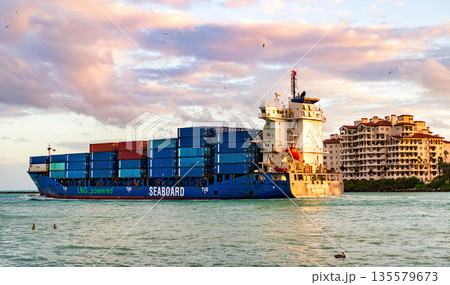 Miami, Florida, USA - December 14, 2024: Cargo Seaboard blue ship services with container, aerial sunset view. Freight container on cargo vessel. Cargo ship vessel. Miami port. Container ship 135579673