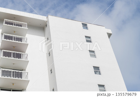 Residential white building architecture. Architectural exterior. House exterior fragment. Modern apartment building facade. Apartment building with exterior detail. View of building facade 135579679