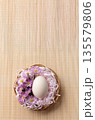 Minimal Easter Egg with Pink Flowers in Basket on Natural Bamboo Background 135579806
