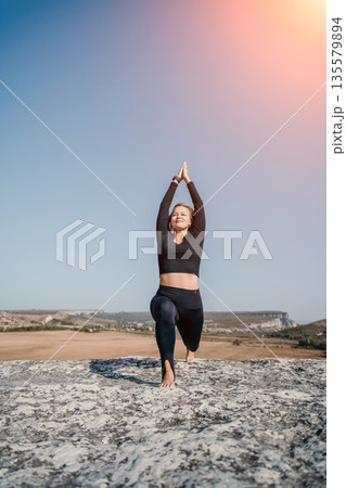 Woman Practicing Yoga on a Rocky Outcrop Woman Practicing Yoga on a Rocky Outcrop 135579894