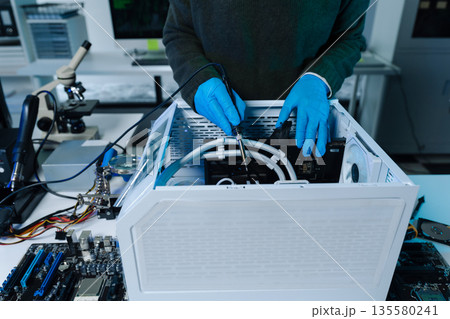 Hands repairing electronic devices. Electronic technician. 135580241