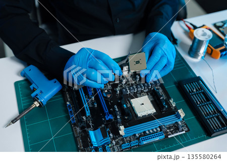 Hands repairing electronic devices. Electronic technician. 135580264