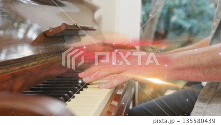 Playing piano, man pressing ivory keys in music room by window with sparkle overlay, copy space Playing piano, man pressing ivory keys in music room by window with sparkle overlay, copy space 135580439