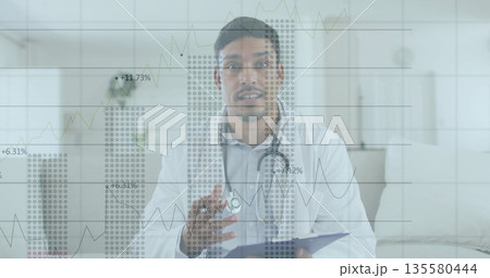 Showing South Asian doctor gesturing at home, with clipboard pen stethoscope and data charts Showing South Asian doctor gesturing at home, with clipboard pen stethoscope and data charts 135580444