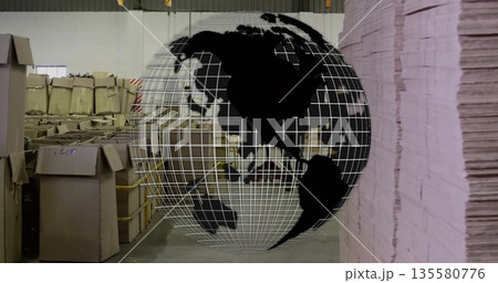 Projecting wireframe globe overlaying in warehouse showing cardboard boxes on pallets, pink sheets 135580776
