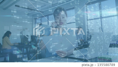 Woman holding documents and speaking on smartphone in open plan office with city skyline Woman holding documents and speaking on smartphone in open plan office with city skyline 135580789