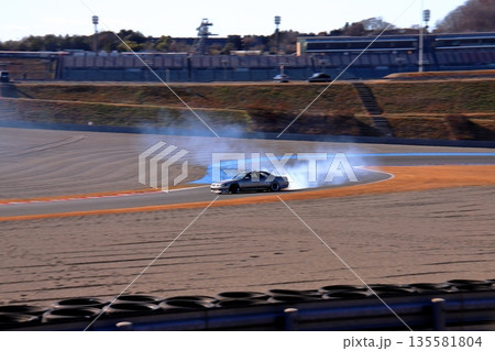 ドリフトする銀色のセダン車 135581804