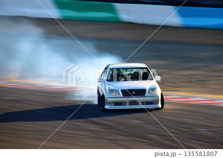 ドリフトする白色のセダン車 135581807