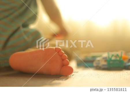 おもちゃで遊ぶ5歳児の足 135581811