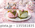 ひな祭りの二色桜餅と雛人形　春の和菓子イメージ 135581835