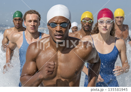 Athlete water swimwear competition running ocean group determination energy action Swimmers colorful swimwear run from ocean water showing 135581945