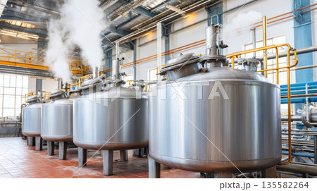 Large stainless steel tanks with steam in modern industrial facility, used for chemical or food processing production Large stainless steel tanks with steam in modern industrial facility, used for chemical or food processing production 135582264