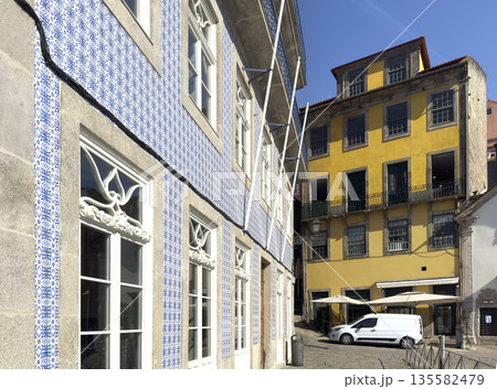 Street view with traditional Portuguese buildings, one decorated with blue azulejo tiles and another 135582479