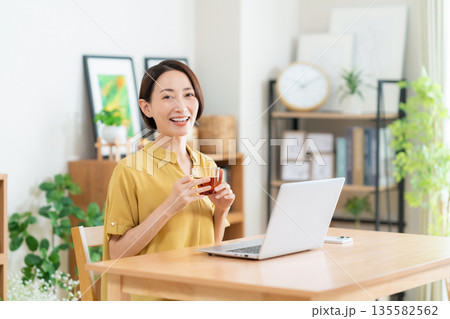 リビングでパソコンを見るミドルの女性 135582562