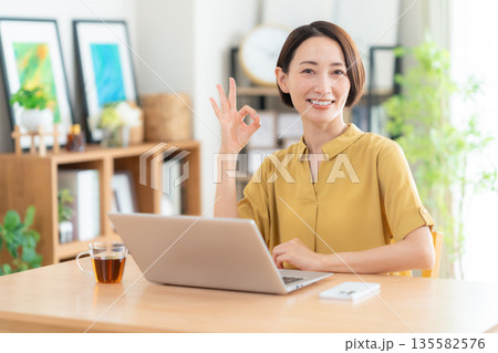 リビングでパソコンを見るミドルの女性 135582576