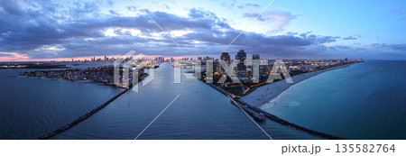 Aerial view of night South Beach coastline. Miami skyline with tropical blue waters panorama. Panorama over the Miami skyscrapers at dusk. Aerial view of night South Beach coastline. Miami skyline with tropical blue waters panorama. Panorama over the Miami skyscrapers at dusk. 135582764