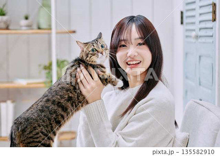 猫を抱っこして微笑む日本人女性 猫を抱っこして微笑む日本人女性 135582910