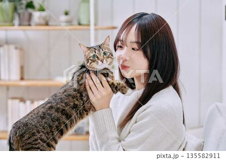 猫を抱っこして微笑む日本人女性 猫を抱っこして微笑む日本人女性 135582911