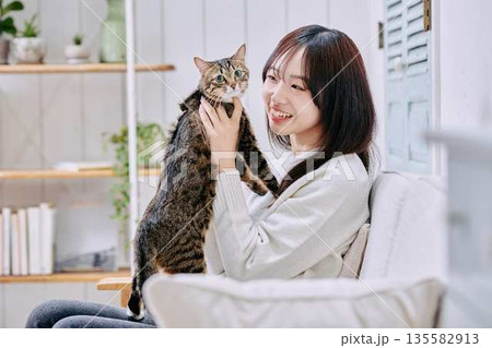 猫を抱っこして微笑む日本人女性 猫を抱っこして微笑む日本人女性 135582913