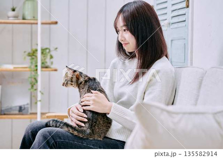 猫を抱っこして微笑む日本人女性 猫を抱っこして微笑む日本人女性 135582914