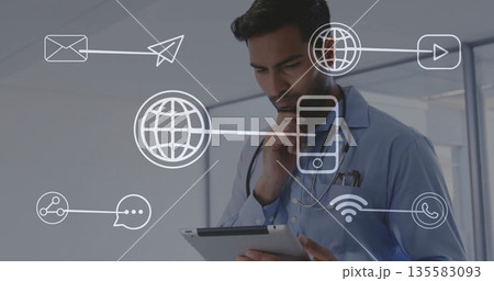 Doctor wearing blue shirt and stethoscope holding tablet analyzing data in office, with tech icons Doctor wearing blue shirt and stethoscope holding tablet analyzing data in office, with tech icons 135583093