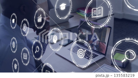 Thinking man in blue shirt looking at laptop on office desk with digital icons, copy space 135583219
