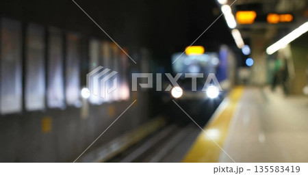 Approaching subway train moving into underground platform, with headlights and yellow safety line Approaching subway train moving into underground platform, with headlights and yellow safety line 135583419