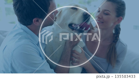 Kissing man and smiling woman cuddling retriever dog on couch in bright living room Kissing man and smiling woman cuddling retriever dog on couch in bright living room 135583433