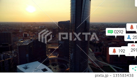 Bathing glass skyscrapers absorbing golden sunset light over city center, with notification icons 135583438