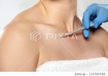 Procedure taking place on a person's collarbone area during a medical treatment session 135583580