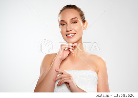 Woman smiling and showing hands while posing for a studio session with a neutral background Woman smiling and showing hands while posing for a studio session with a neutral background 135583620