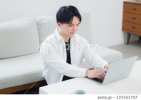 パソコンを操作する若い男性 135583787