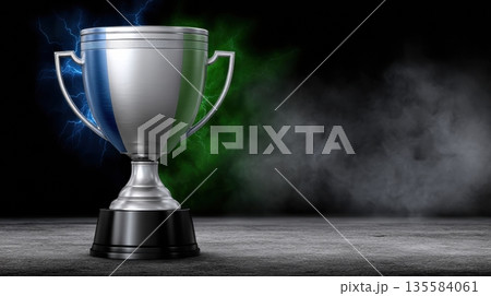 Silver trophy stands on a dark surface with colorful light effects in the background showcasing a competitive achievement moment 135584061